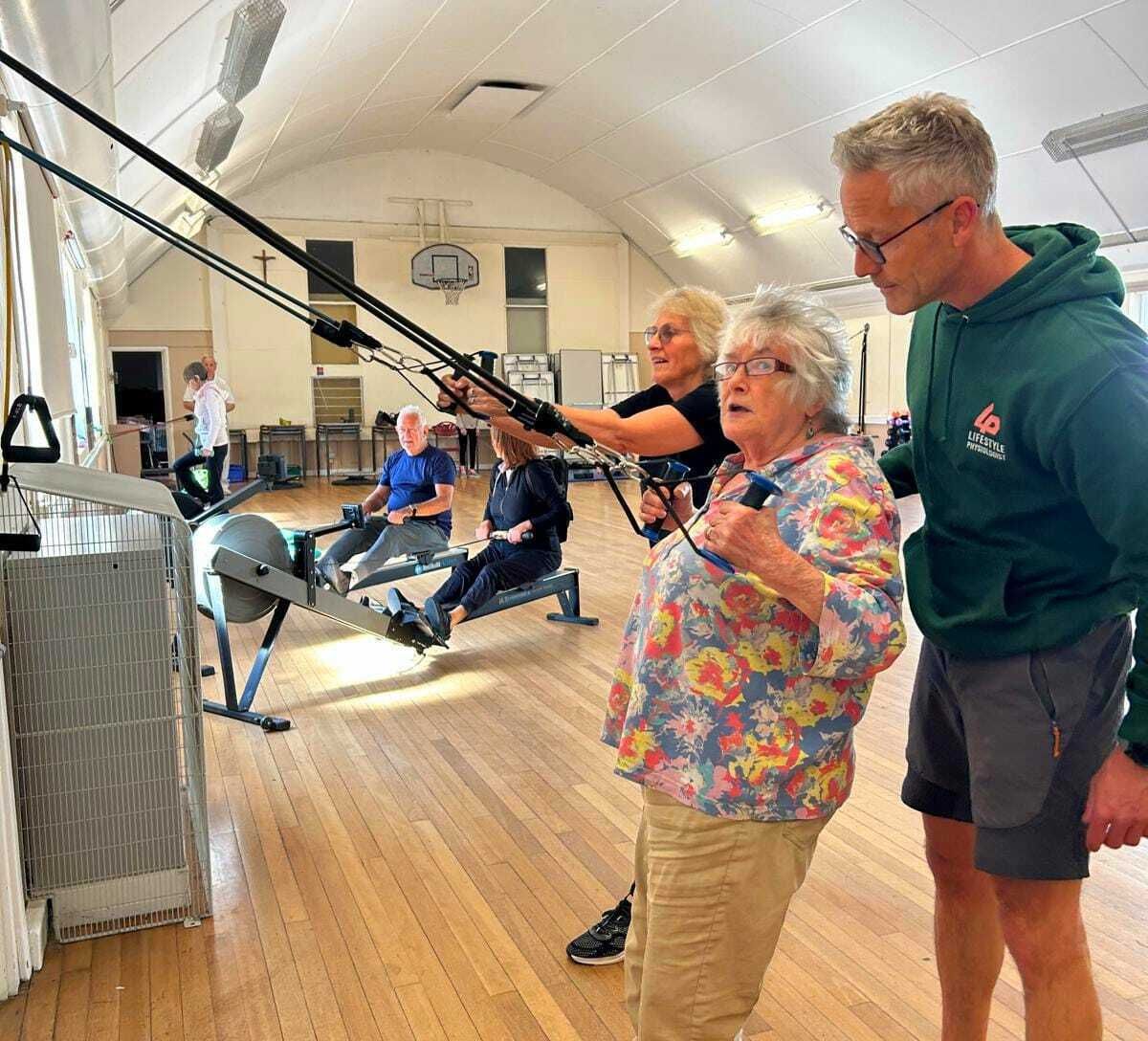 Participants using TRX suspension training with hands-on guidance