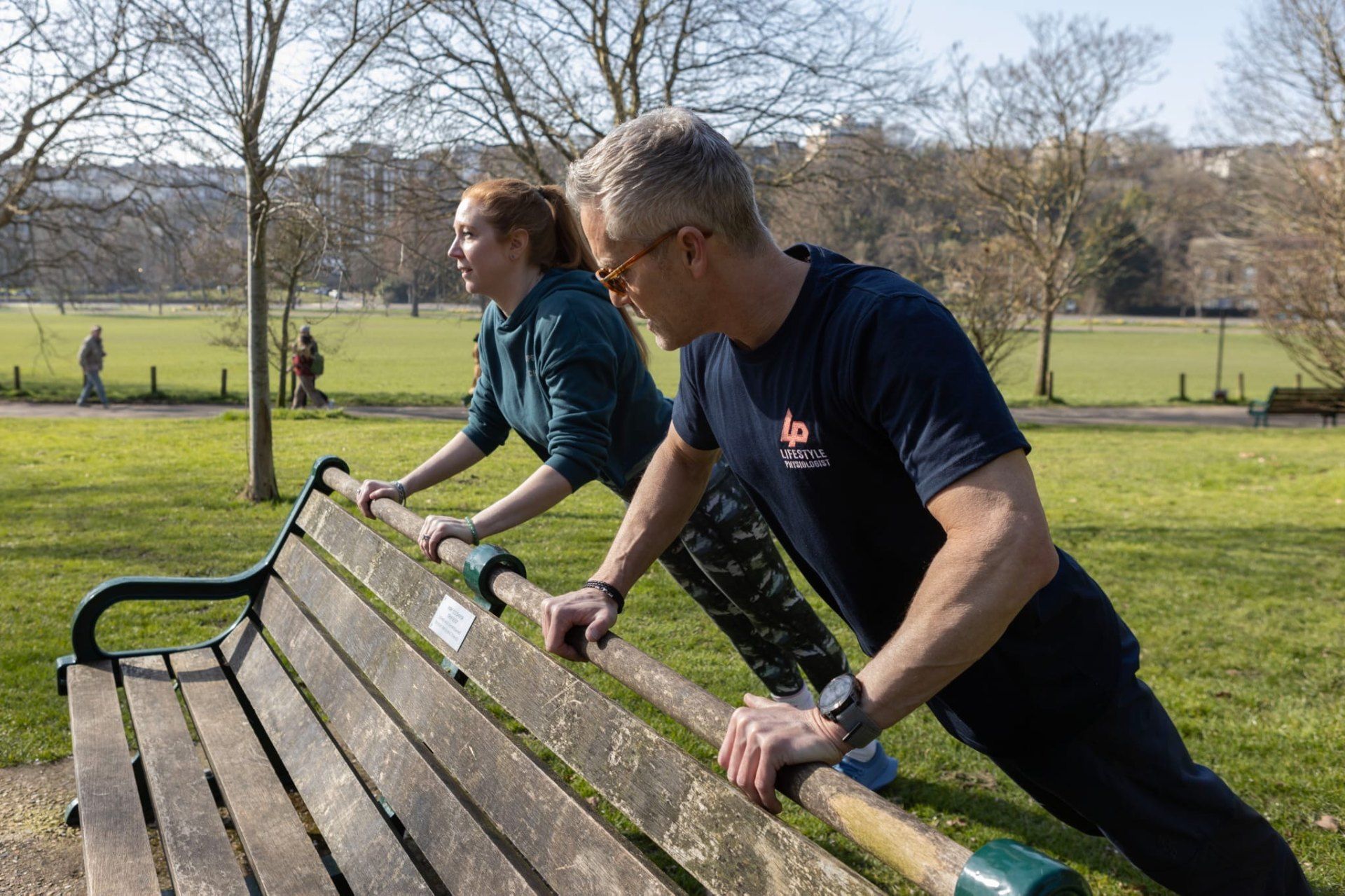 Richard and client doing push-ups on a park bench